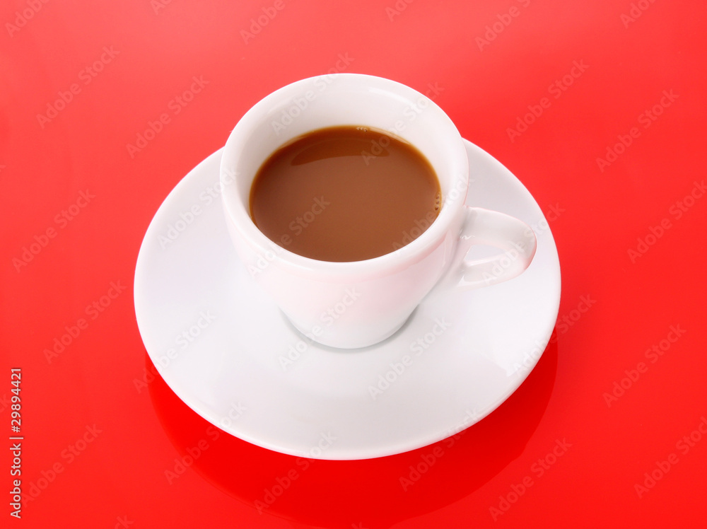 Small white cup with coffee on red background Small white cup with coffee on red background