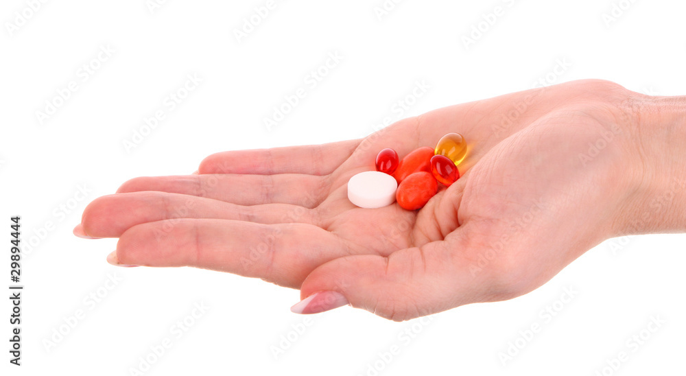 red and yellow capsules of vitamins on the hand on a white back red and yellow capsules of vitamins on the hand on a white back