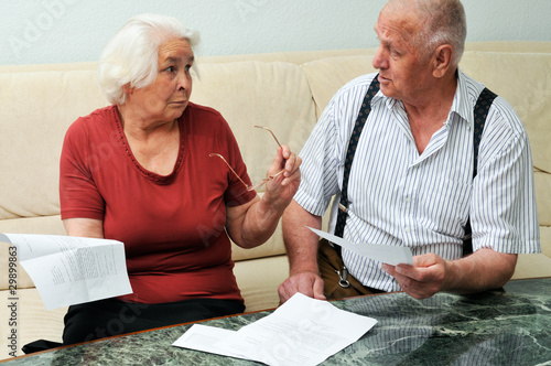 Senior couple reading documents at home