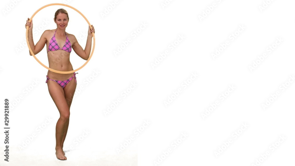 Pretty lady in purple swimsuit playing with a hoop