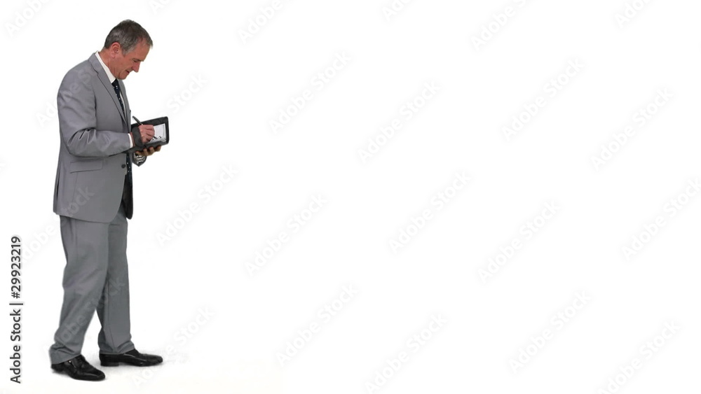 Senior businessman writing something on his diary Senior businessman writing something on his diary