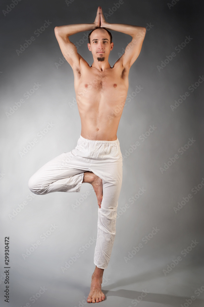 Handsome young man in yoga position Studio portrate over gray Handsome young man in yoga position Studio portrate over gray