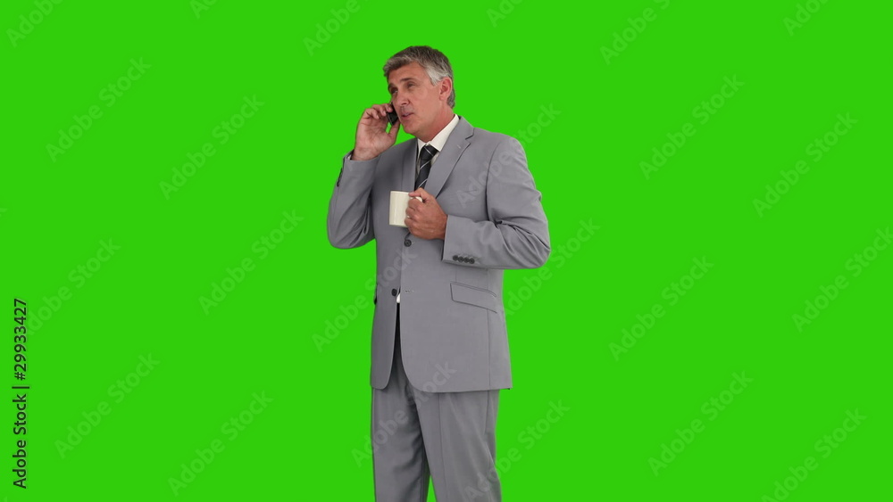 Businessman with a cup of tea having a phone call Businessman with a cup of tea having a phone call