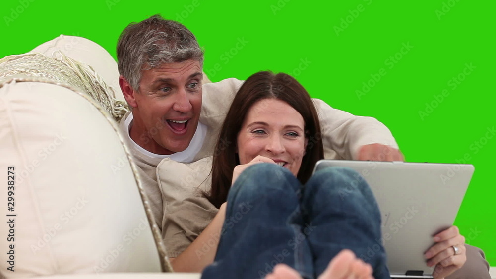Casual mature couple laughing with a laptop Casual mature couple laughing with a laptop