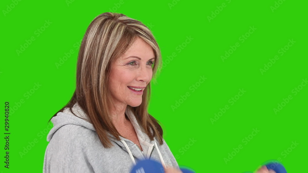Retired woman doing workout with dumbbells Retired woman doing workout with dumbbells