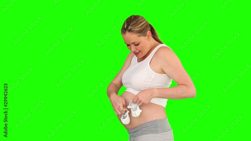 Pregnant woman touching her belly with shoes Pregnant woman touching her belly with shoes