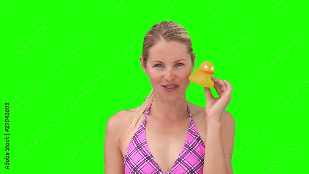 Blond woman in purple swimsuit playing with a plastic duck Blond woman in purple swimsuit playing with a plastic duck