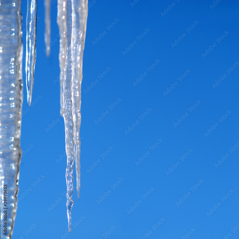 Long icicles hangs over blue cloudless sky Long icicles hangs over blue cloudless sky