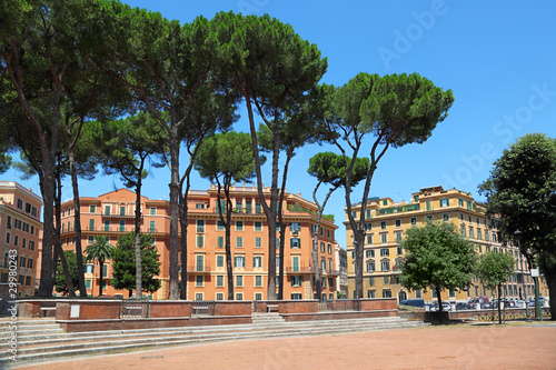 multi-storey yellow houses in Rome, high green trees, blue sky