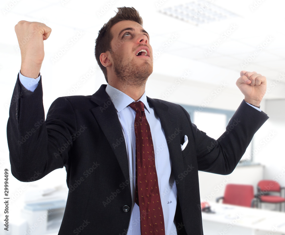 Happy businessman gesturing success in the office