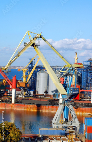 Container stacks un harbor under crane bridge