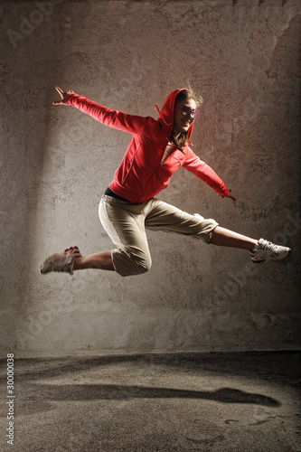 young female dancing on the grey wall background