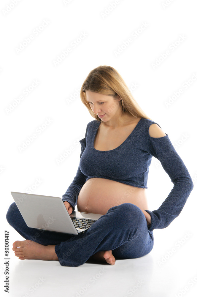pregnant woman with a laptop sitting on the floor pregnant woman with a laptop sitting on the floor