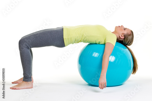 junge frau liegt mit den schultern auf gymnastikball photo