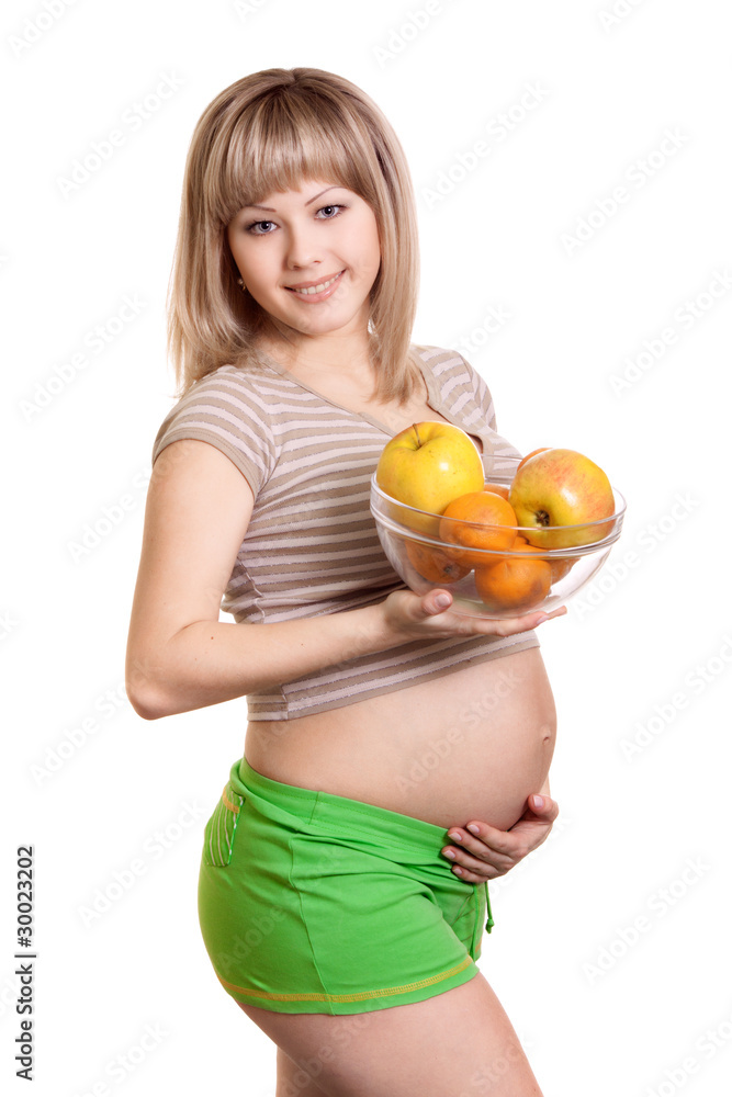 Portrait of pregnant woman with fruits in dish isolated on white