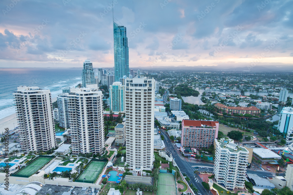 Obraz premium view over the modern city at twilight with ocean beside