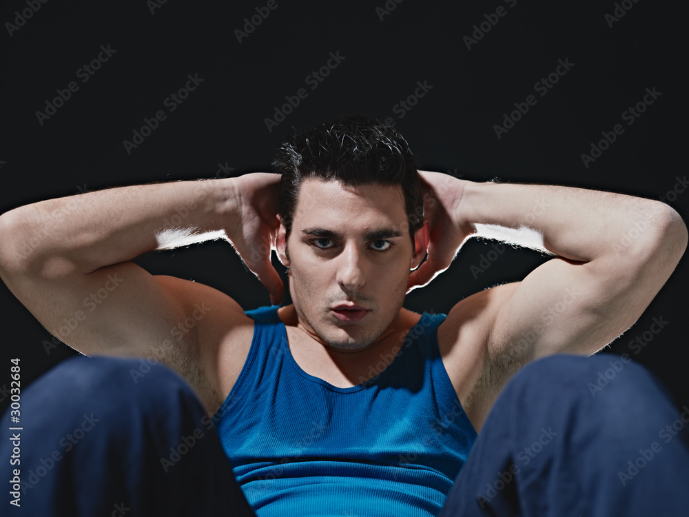 man doing series of sit-ups on black background