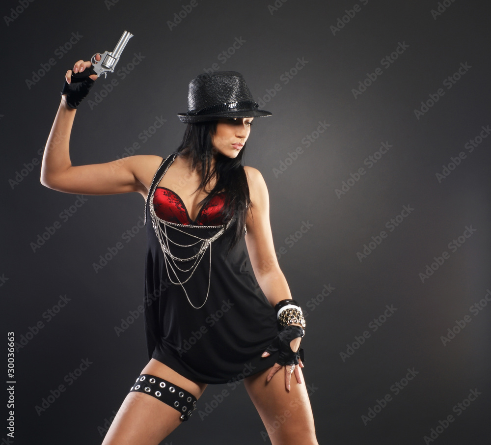 A young and sexy brunette in an evening dress with a gun A young and sexy brunette in an evening dress with a gun