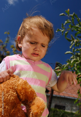 Foto Tired and sorrowful child with her teddy bear