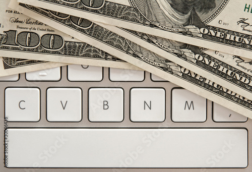 Money bills on computer keyboard with spacebar photo