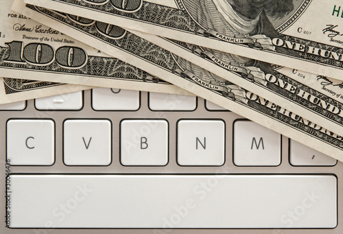 Money bills on computer keyboard with spacebar