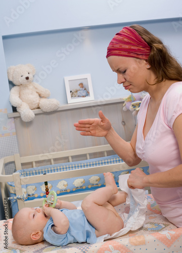 mother changing baby's diaper