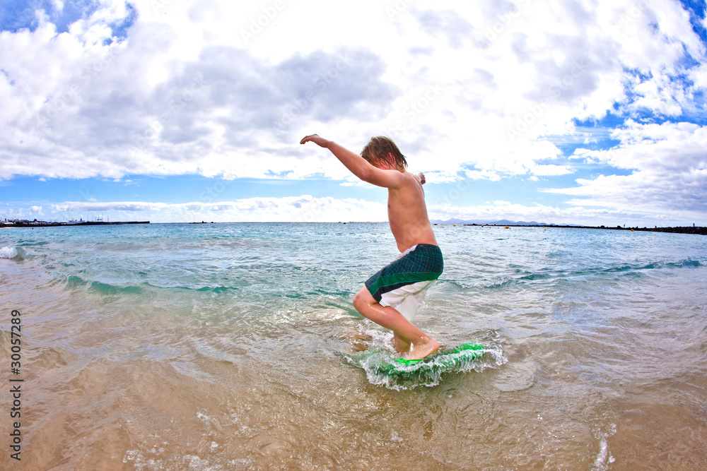 boy has fun at the beach with the surfboard