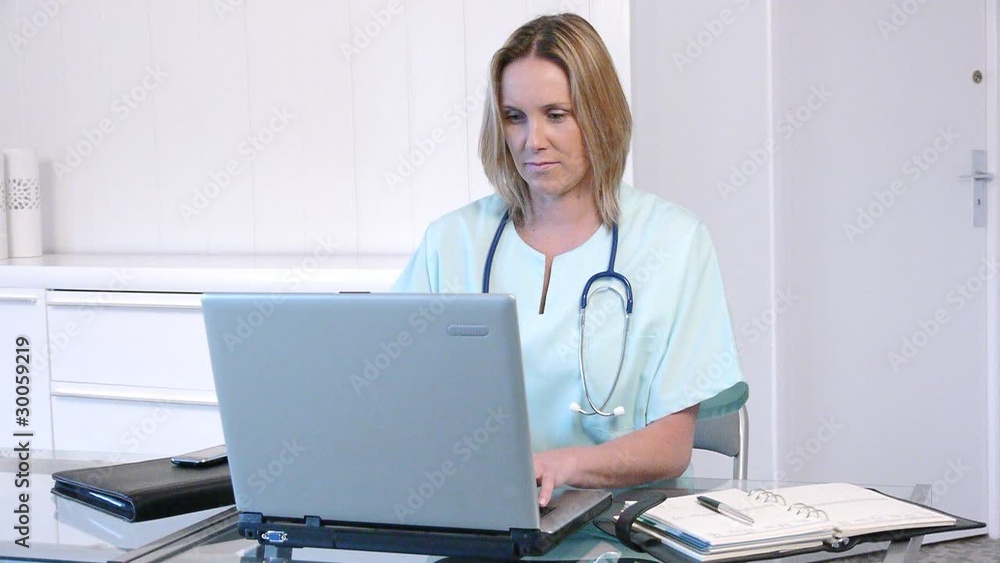 Nurse in the office working on laptop computer Nurse in the office working on laptop computer