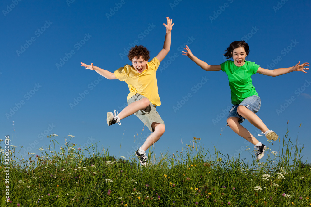 Girl and boy jumping, running against blue sky Girl and boy jumping, running against blue sky