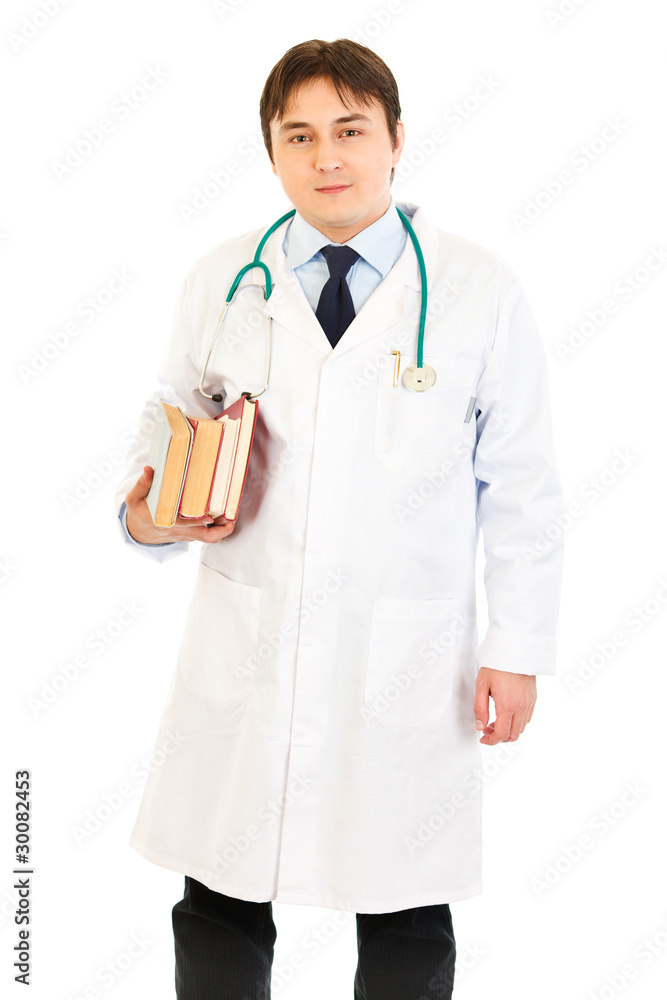 Smiling doctor holding several medical books in hands Smiling doctor holding several medical books in hands