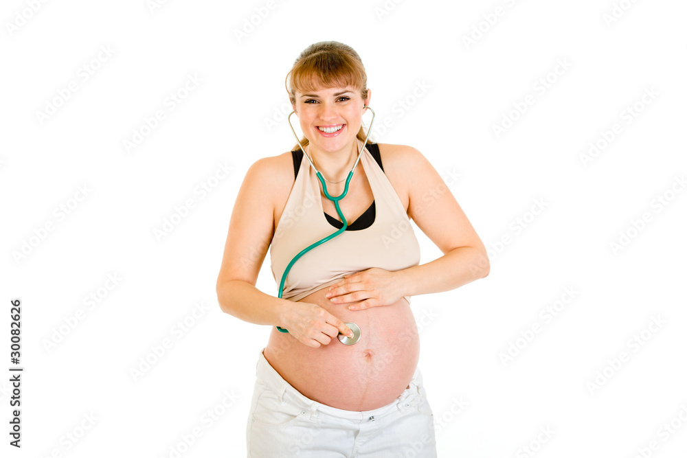 Smiling pregnant woman holding stethoscope on her tummy Smiling pregnant woman holding stethoscope on her tummy