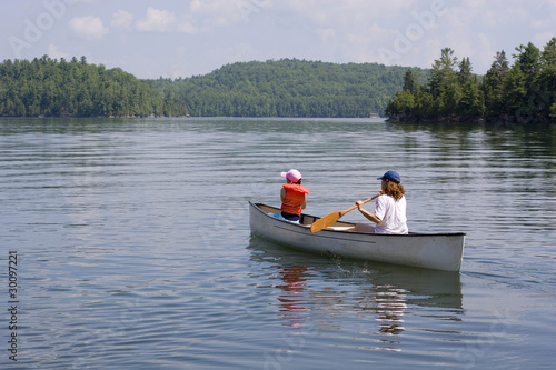 Mother and daughter canoeing on a lake