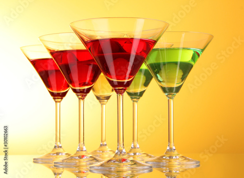 a few glasses of alcoholic drinks in a yellow-brown background