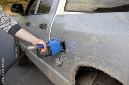 Man pumping gas into a pickup truck