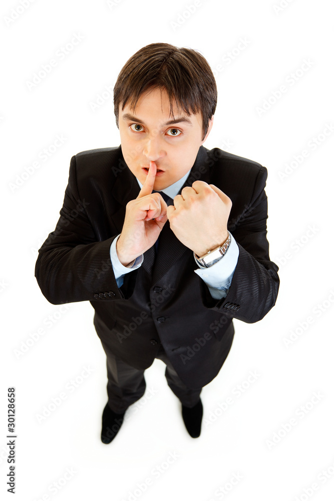 Angry businessman with finger at mouth and threaten with fist Angry businessman with finger at mouth and threaten with fist