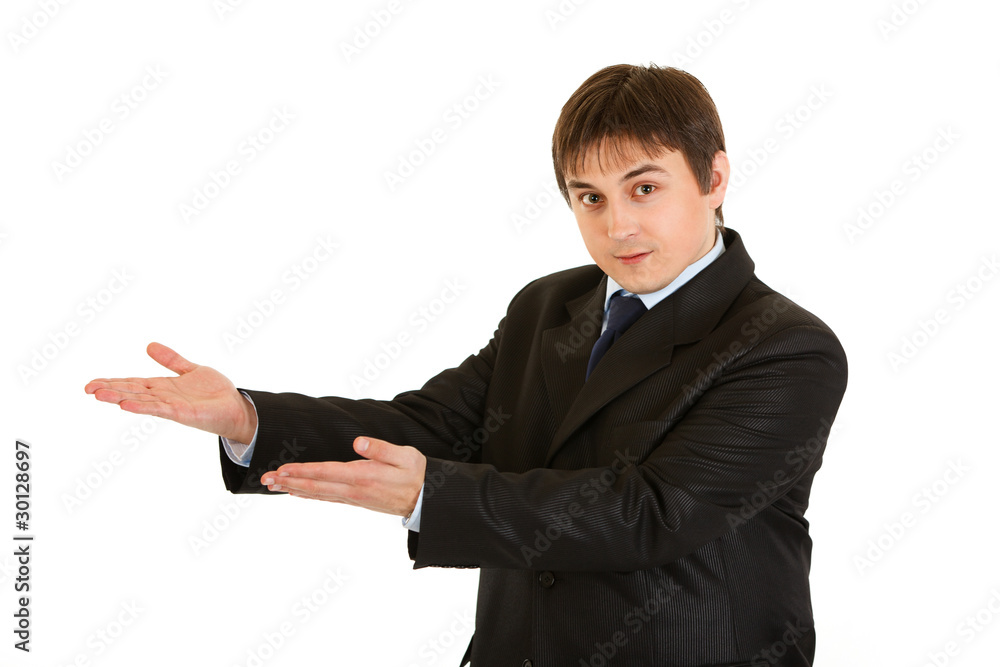 Smiling businessman presenting something on empty hands Smiling businessman presenting something on empty hands