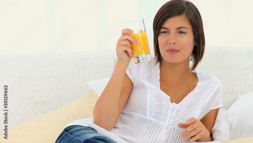 Cute brunette woman drinking a glass of orange juice Cute brunette woman drinking a glass of orange juice