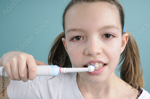 girl brushing teeth with toothbrush