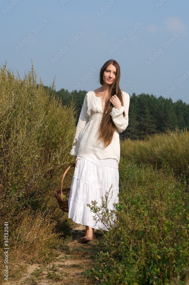 beautiful woman with busket at the summer field