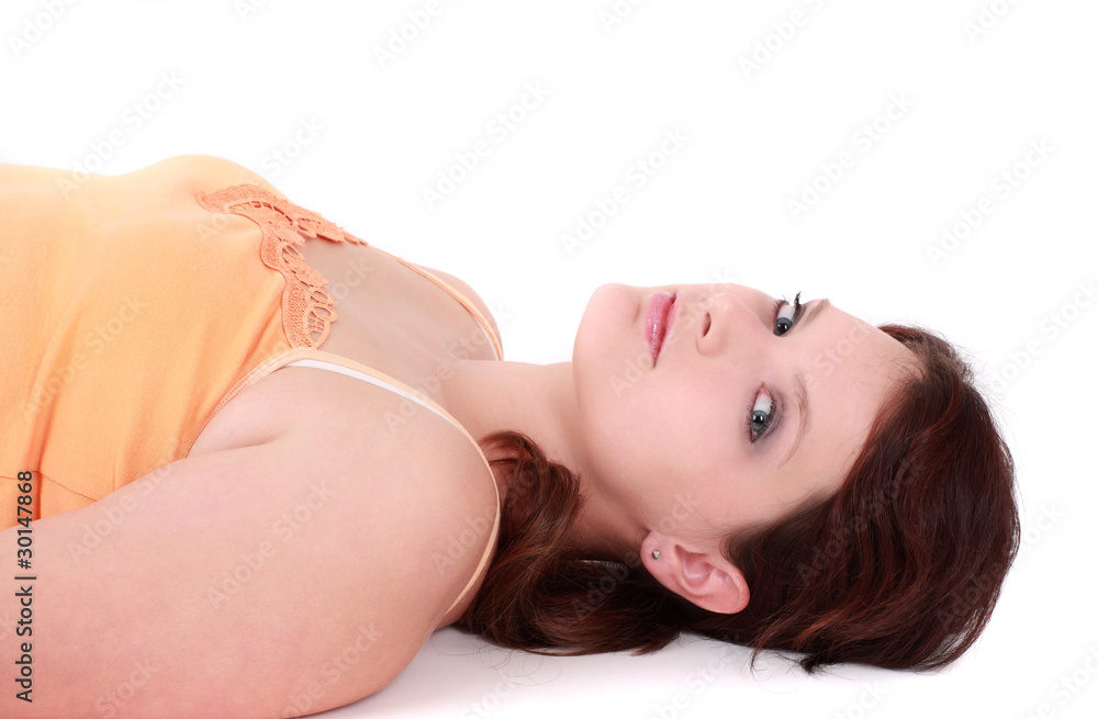 Naklejka premium Portrait of teenage girl lying down, studio shot