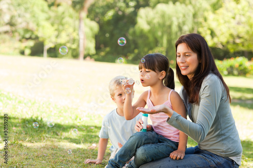 Family blowing bubbles in the park