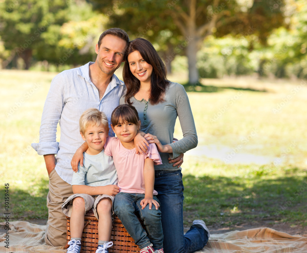 Smiling family picnicking in the park