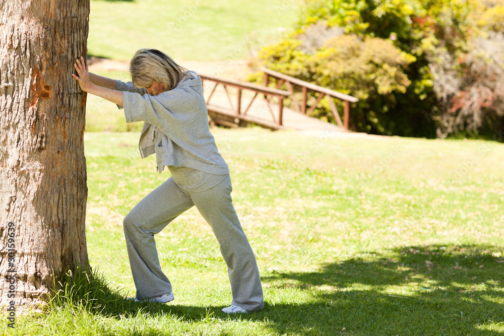 Mature woman doing her streches in the park Mature woman doing her streches in the park