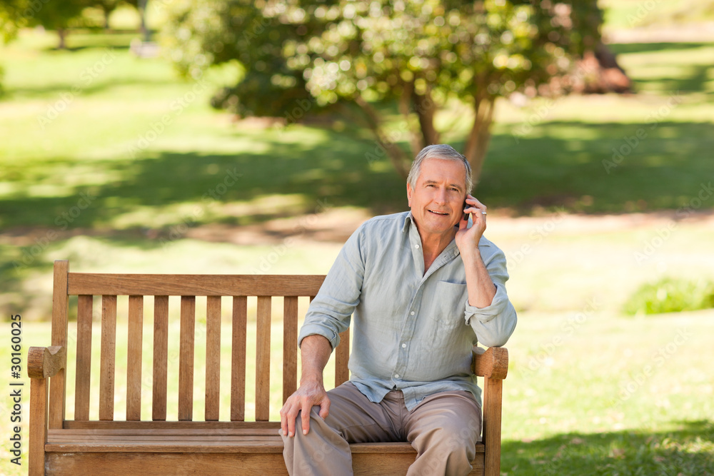 Fototapeta premium Retired man phoning in the park