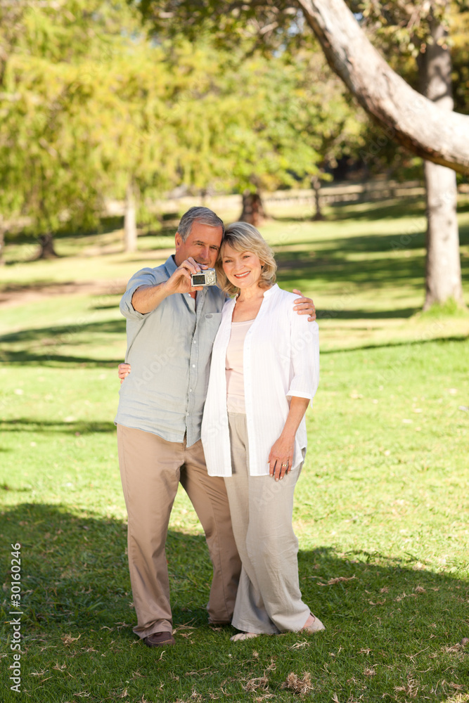 Elderly couple taking a photo of themselves in the park Elderly couple taking a photo of themselves in the park