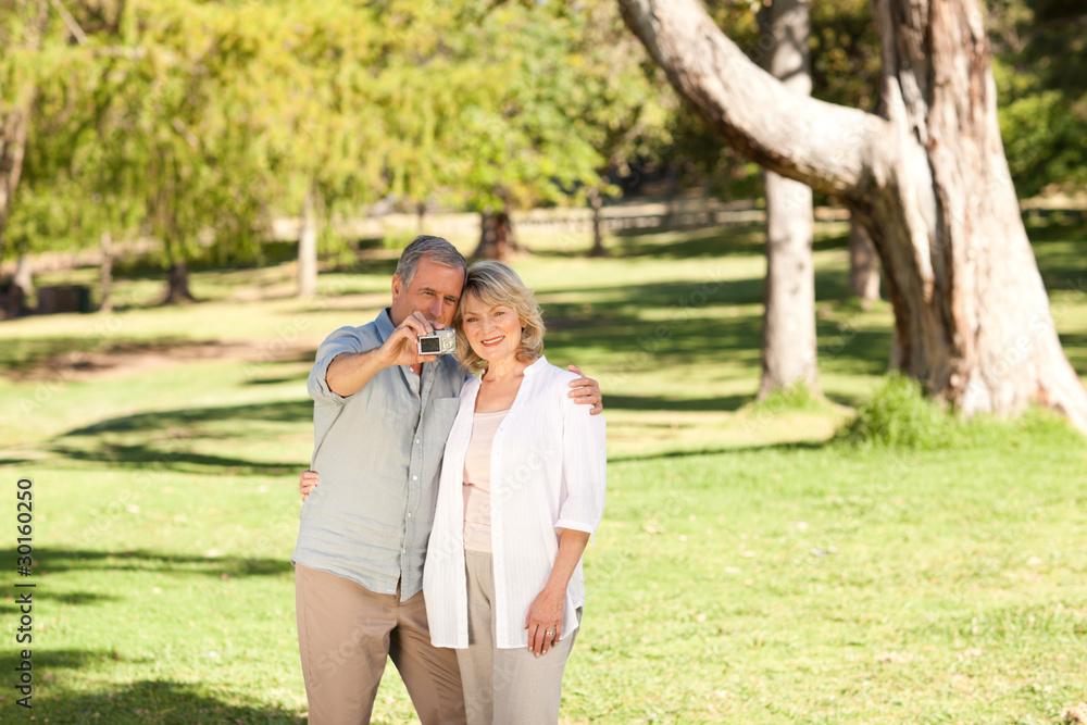 Elderly couple taking a photo of themselves in the park Elderly couple taking a photo of themselves in the park