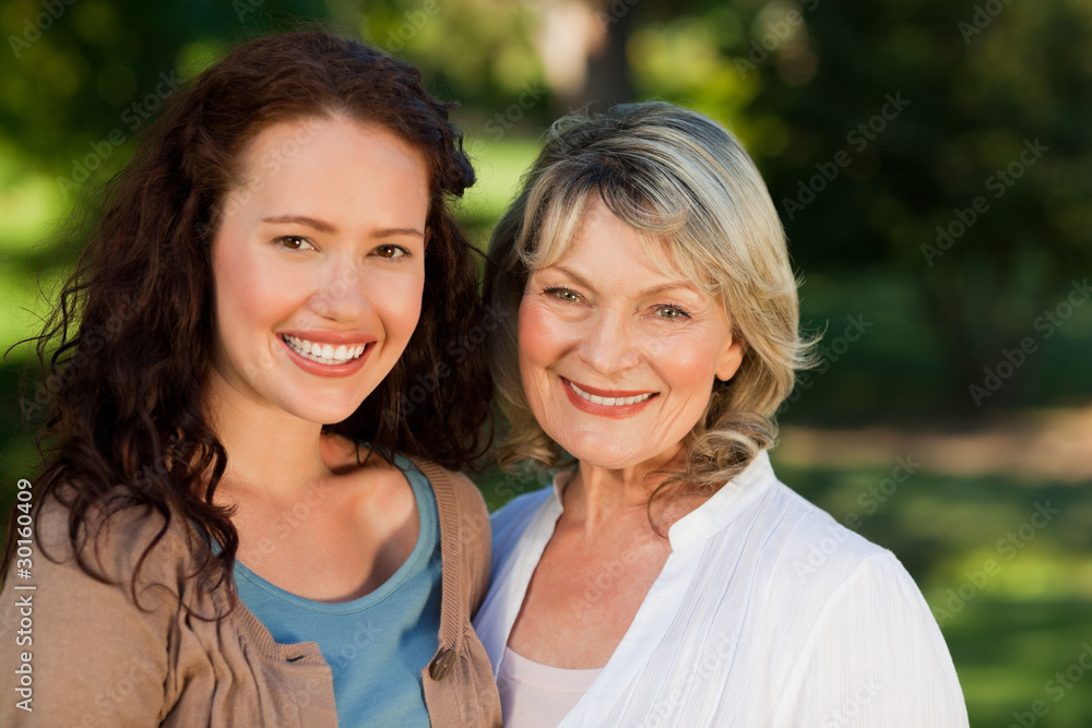 Mother with her daughter looking at the camera in the park Mother with her daughter looking at the camera in the park