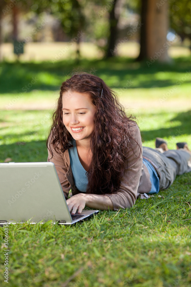 Woman working on her laptop in the park Woman working on her laptop in the park