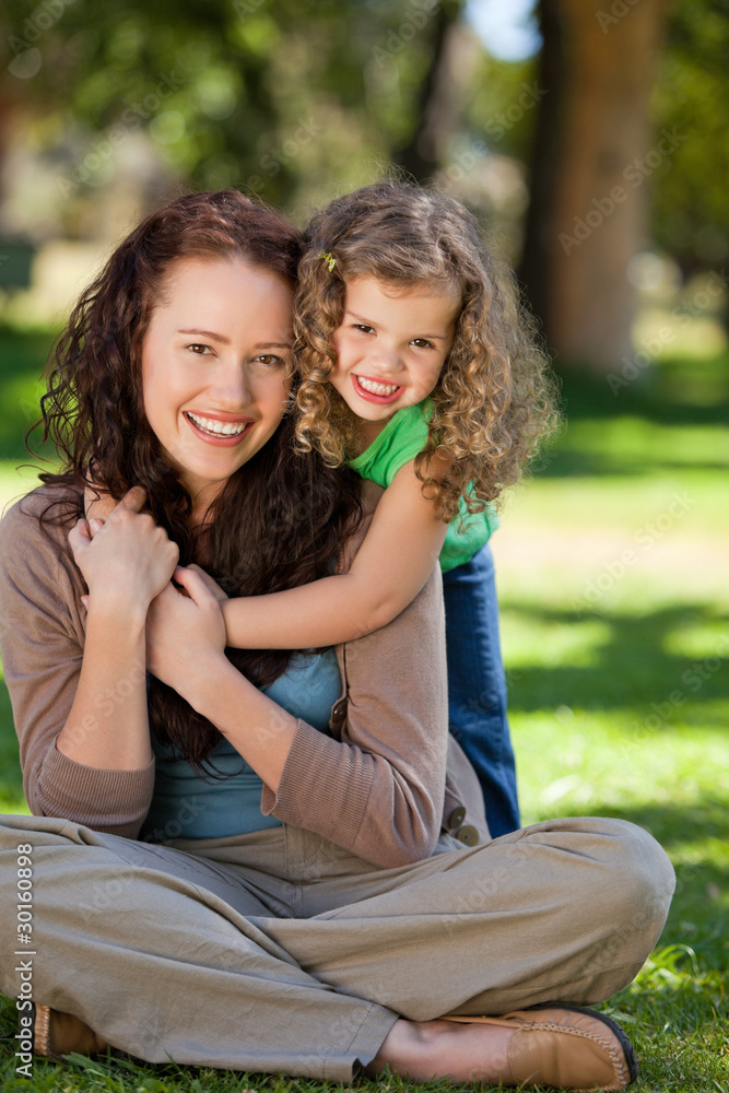 Woman hugging her daughter in the park Woman hugging her daughter in the park