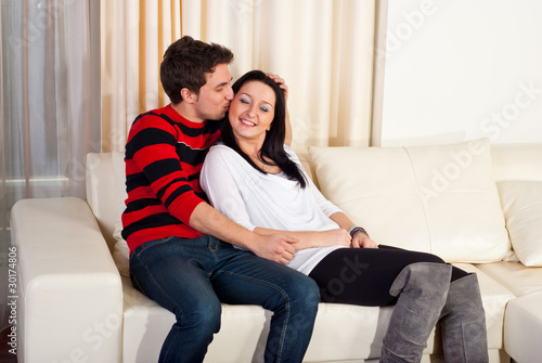 Loving young couple on sofa home